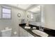 Well-lit bathroom with black countertops, white cabinets, and a comfortable toilet at 3278 Village Green Dr # 1024, Sarasota, FL 34239