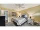 Cozy bedroom featuring gray carpet and walls, white ceiling fan, and side tables with lamps at 3278 Village Green Dr # 1024, Sarasota, FL 34239