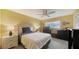 A primary bedroom features a ceiling fan, window with blinds, and dressers for storage at 3278 Village Green Dr # 1024, Sarasota, FL 34239