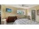 A well-lit bedroom featuring a TV, chair, and dresser near the window at 3278 Village Green Dr # 1024, Sarasota, FL 34239