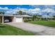 Charming one-story home featuring an attached garage, lush landscaping, and a spacious driveway at 3278 Village Green Dr # 1024, Sarasota, FL 34239