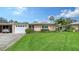 Inviting single-story home boasts a well-manicured lawn, attached garage, and mature landscaping at 3278 Village Green Dr # 1024, Sarasota, FL 34239
