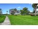 Manicured front lawn with lush grass and scattered trees at 3278 Village Green Dr # 1024, Sarasota, FL 34239