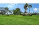 Well-maintained front yard featuring lush lawn and mature trees, offering a serene view at 3278 Village Green Dr # 1024, Sarasota, FL 34239