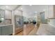 Open-concept kitchen with stainless refrigerator, white upper cabinets and view of living room at 3278 Village Green Dr # 1024, Sarasota, FL 34239