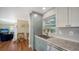Bright kitchen features stainless sink and granite countertop with gray cabinets, plus view to living room at 3278 Village Green Dr # 1024, Sarasota, FL 34239