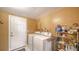 Laundry room with white machines, adjacent to a white door, and a neat storage rack at 3278 Village Green Dr # 1024, Sarasota, FL 34239