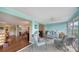 Sunlit living room adjoining the dining area and featuring comfortable blue patio furniture at 3278 Village Green Dr # 1024, Sarasota, FL 34239