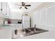 Well-maintained kitchen featuring white cabinets, a stainless steel sink, and neutral-toned flooring for a clean and inviting space at 3300 Loveland Blvd # 3203, Punta Gorda, FL 33980