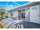 A covered patio with a table and chairs leads to a sliding glass door and a white door with an arched window at 3300 Loveland Blvd # 3203, Punta Gorda, FL 33980