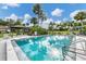 Community swimming pool with ample seating, palm trees, and a tranquil setting at 3523 Longmeadow # 12, Sarasota, FL 34235