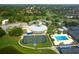 Aerial view of tennis courts and pool. Clubhouse is located at a golf course and surrounded by beautiful, mature trees at 3837 Torrey Pines Blvd, Sarasota, FL 34238