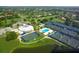 A full view of tennis courts, golf course, clubhouse, pool, and residences in a beautiful, landscaped community at 3837 Torrey Pines Blvd, Sarasota, FL 34238