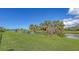 Lush, green backyard with water and golf course views behind tropical foliage at 3837 Torrey Pines Blvd, Sarasota, FL 34238