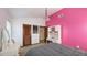 Bedroom with a desk, closet, pink accent wall, and comfortable bed at 3837 Torrey Pines Blvd, Sarasota, FL 34238