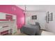 Bright bedroom features a desk with shelves, pink accent wall, and comfortable bed at 3837 Torrey Pines Blvd, Sarasota, FL 34238