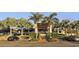 Beautiful community clubhouse entrance with mature palm trees and well-manicured landscaping at 3837 Torrey Pines Blvd, Sarasota, FL 34238