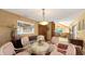 Elegant dining room with a glass table, seating for six, and an open view to the living area at 3837 Torrey Pines Blvd, Sarasota, FL 34238