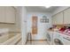 Bright laundry room featuring tile floors, sink, storage cabinets, washer, and dryer at 3837 Torrey Pines Blvd, Sarasota, FL 34238