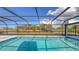 Private screened-in pool with clear blue water and view of the backyard pond at 3837 Torrey Pines Blvd, Sarasota, FL 34238
