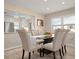 Bright dining area showcases a modern glass-top table with elegant neutral colored chairs and updated flooring at 4721 Mount Vernon Dr, Bradenton, FL 34210