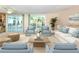 Light-filled living room with stylish seating, neutral tones, and access to a private balcony at 4822 Ocean Blvd # 2D, Sarasota, FL 34242