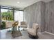 Elegant waiting area with chic seating, a glass coffee table, and a large window overlooking a beautiful green space at 4822 Ocean Blvd # 2D, Sarasota, FL 34242