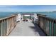 Relaxing pier featuring a table and chairs, providing a tranquil spot to enjoy the stunning ocean views at 4822 Ocean Blvd # 2D, Sarasota, FL 34242