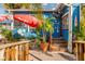 Inviting outdoor seating area with a colorful blue exterior and lush tropical landscaping at 4822 Ocean Blvd # 2D, Sarasota, FL 34242