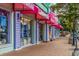 Shops on Siesta Key Village with colorful awnings along a brick sidewalk lined with trees at 4822 Ocean Blvd # 2D, Sarasota, FL 34242