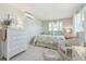 Cozy bedroom featuring light green walls, wicker furniture and a queen size bed with floral bedding at 4912 Beacon Rd, Palmetto, FL 34221