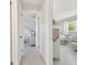 Bright hallway leads to bedrooms with white furnishings and wicker chairs at 4912 Beacon Rd, Palmetto, FL 34221