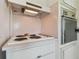 Classic white stove and oven built into white cabinets and light pink backsplash and countertops at 4912 Beacon Rd, Palmetto, FL 34221