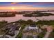 Sunset aerial shot of the property showcasing the house, landscaping, and scenic waterway views at 525 S Shore Dr, Osprey, FL 34229