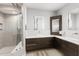 Modern bathroom with a glass-enclosed shower and dark wood cabinets with double sinks at 525 S Shore Dr, Osprey, FL 34229