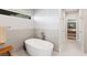 Elegant bathroom featuring a standalone tub, tiled walls, and a view into the main bedroom at 525 S Shore Dr, Osprey, FL 34229