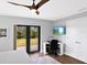 Bright bedroom featuring a ceiling fan, area rug, desk, and sliding glass doors leading to the backyard at 525 S Shore Dr, Osprey, FL 34229