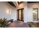 Elegant front door with sidelights, sleek lighting, and stylish landscaping, creating a welcoming entrance at 525 S Shore Dr, Osprey, FL 34229