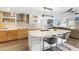 Modern kitchen featuring an island with seating, custom cabinets, stainless steel appliances, and tile backsplash at 525 S Shore Dr, Osprey, FL 34229