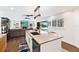 Kitchen island featuring granite countertop and built-in dishwasher, overlooks the living area and outdoor pool at 525 S Shore Dr, Osprey, FL 34229
