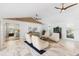 Bright living room featuring vaulted ceilings with fans, white walls and couches, and light marble floors at 525 S Shore Dr, Osprey, FL 34229
