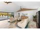 Bright living room with stylish seating, modern decor, and seamless access to outdoor pool area at 525 S Shore Dr, Osprey, FL 34229