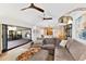 Cozy living room featuring a large gray sectional, modern lighting, and a view into the kitchen and patio area at 525 S Shore Dr, Osprey, FL 34229