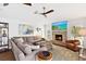 Comfortable living room with a stone fireplace, large sectional sofa, and bright natural light through shuttered windows at 525 S Shore Dr, Osprey, FL 34229