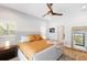 Cozy main bedroom with a large bed, neutral tones, shuttered windows, and stylish decor with a ceiling fan at 525 S Shore Dr, Osprey, FL 34229