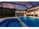 Inviting screened-in pool with a spa, water feature, and lush landscaping, perfect for relaxing and entertaining at 525 S Shore Dr, Osprey, FL 34229