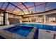 Gorgeous screened-in pool and spa area with a seamless transition to an outdoor kitchen and dining space at 525 S Shore Dr, Osprey, FL 34229