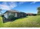 View of the back exterior of the home with screened lanai and well-manicured lawn at 5946 Caspian Tern Dr, Sarasota, FL 34238