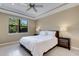 Cozy bedroom featuring a king-sized bed, tray ceiling, and natural light from the window, creating a tranquil retreat at 5946 Caspian Tern Dr, Sarasota, FL 34238