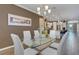 Bright dining room with a modern glass table, seating for six, and views into the open-concept kitchen at 5946 Caspian Tern Dr, Sarasota, FL 34238